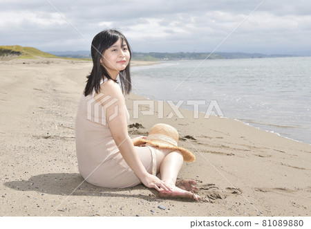 Taking a portrait of a woman in a mini one-piece in a straw hat on the coast of Esashi-cho, Hokkaido in midsummer 81089880