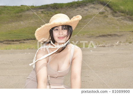 Taking a portrait of a woman in a mini one-piece in a straw hat on the coast of Esashi-cho, Hokkaido in midsummer 81089900