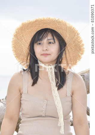 Taking a portrait of a woman in a mini one-piece in a straw hat on the coast of Esashi-cho, Hokkaido in midsummer Taking a portrait of a woman in a mini one-piece in a straw hat on the coast of Esashi-cho, Hokkaido in midsummer 81090371
