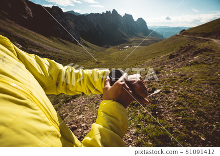 Woman on high altitude mountain top checking the altimeter on the sports watch 81091412