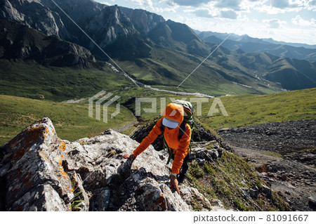 Successful woman backpacker hiking on sunset alpine mountain peak Successful woman backpacker hiking on sunset alpine mountain peak 81091667