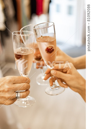 Beautiful female hands are holding glasses of champagne or rose wine. Close-up. Women clink glasses. New Years celebration, event or party. Soft focus. Human hands. Vertical shot Beautiful female hands are holding glasses of champagne or rose wine. Close-up. Women clink glasses. New Years celebration, event or party. Soft focus. Human hands. Vertical shot 81092086