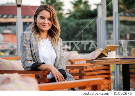 Charming young business lady sitting at the table outdoors 81092676