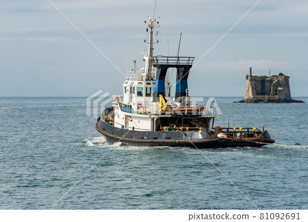 Tug Boat in motion in the Harbor of La Spezia Italy - Ancient Scola Tower Tug Boat in motion in the Harbor of La Spezia Italy - Ancient Scola Tower 81092691