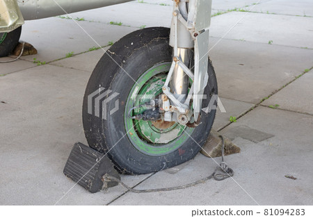 Old black flat wheel of an fighter jet Old black flat wheel of an fighter jet 81094283