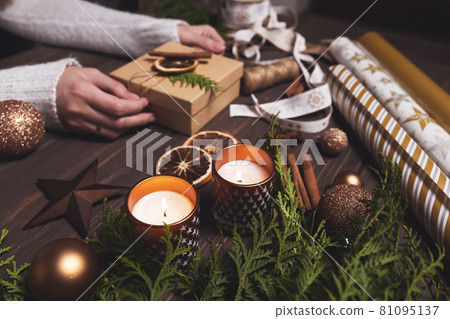 Women's hands decorate Christmas gift box with eco-friendly natural decorations. Diy hobby. 81095137