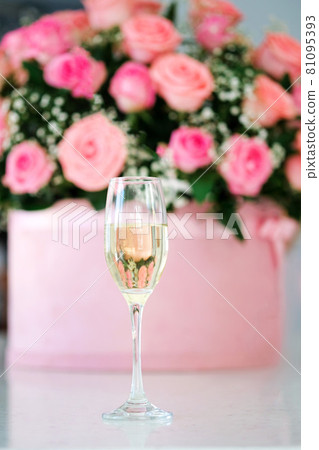 Close-up image of glass of champagne.Bride day dream. Beautiful wedding details and decoration,bouquet with pink roses in box on background. Close-up image of glass of champagne.Bride day dream. Beautiful wedding details and decoration,bouquet with pink roses in box on background. 81095393