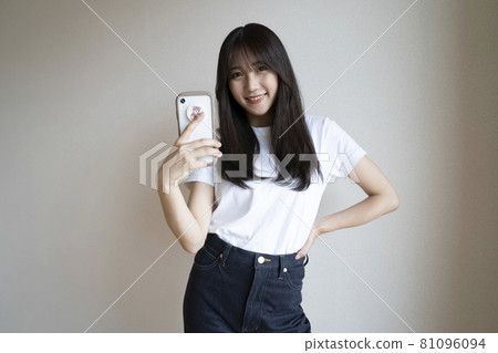 A woman watching a smartphone A woman watching a smartphone 81096094
