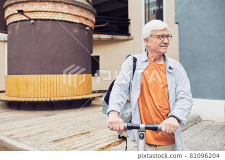 Mature Man Riding Scooter in City 81096204