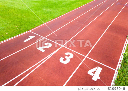 Aerial view of sports stadium with red running tracks with numbers on it and green grass football field. 81098046