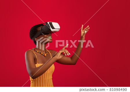 Excited young black woman having virtual reality glasses experience 81098490