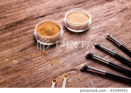 Loose compact mineral powder for face and a brushes for powder and visage on wooden background. Eco friendly and organic cosmetics. Loose compact mineral powder for face and a brushes for powder and visage on wooden background. Eco friendly and organic cosmetics. 81098491
