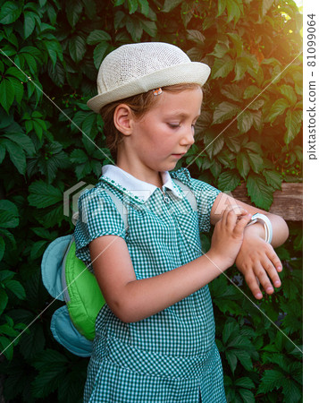 Kid using smartwatch outdoor. Child talking on the smartphone. Schoolgirl using touchscreen on watches browsing internet Kid using smartwatch outdoor. Child talking on the smartphone. Schoolgirl using touchscreen on watches browsing internet 81099064
