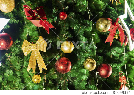 Festive Christmas tree background with decorations. Merry Christmas background. Closeup shot of Christmas tree with Xmas decorations Festive Christmas tree background with decorations. Merry Christmas background. Closeup shot of Christmas tree with Xmas decorations 81099335