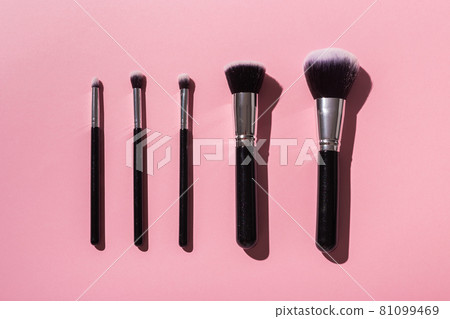 Various make-up brushes on pink background, top view. Cosmetics and beauty concept. 81099469