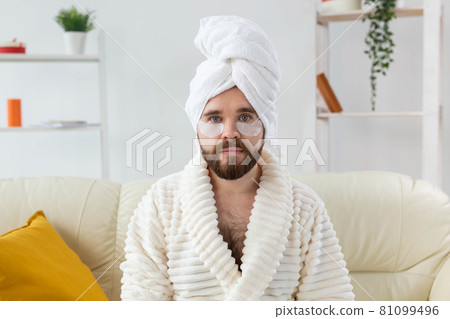 Bearded man sitting with eye patches on his face. Wrinkles and face home care for men. Bearded man sitting with eye patches on his face. Wrinkles and face home care for men. 81099496