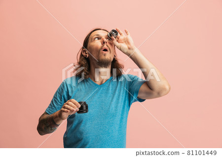 Portrait of young man, photographer, cameraman with camera lens having fun isolated on pink studio background. Concept of occupation, job, funny meme emotions 81101449