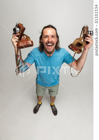 High angle view of young man, photographer, cameraman with retro camera isolated on gray studio background. Concept of occupation, job, funny meme emotions High angle view of young man, photographer, cameraman with retro camera isolated on gray studio background. Concept of occupation, job, funny meme emotions 81101534
