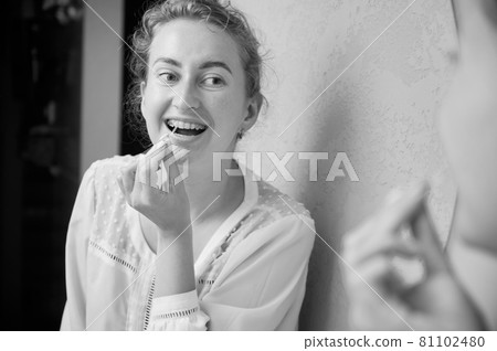 Portrait of woman with braces demonstrating interdental brushing 81102480