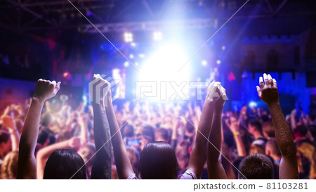 Raised hands of many people in honor of a musical show on stage. People in the hall Raised hands of many people in honor of a musical show on stage. People in the hall 81103281