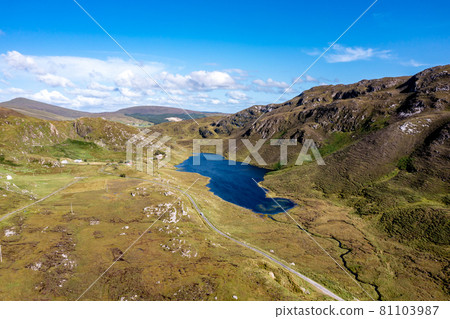 The road to An Port at Kiltyfanned Lough between Ardara and Glencolumbkille in County Donegal - Ireland. The road to An Port at Kiltyfanned Lough between Ardara and Glencolumbkille in County Donegal - Ireland. 81103987