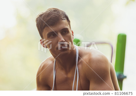 One young handsome caucasian man resting after training at crossfit ground on bright summer day. 81106675