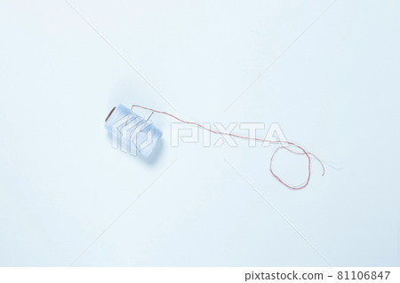 Sewing items flat lays from above. A thread for sewing on bright blue background Sewing items flat lays from above. A thread for sewing on bright blue background 81106847