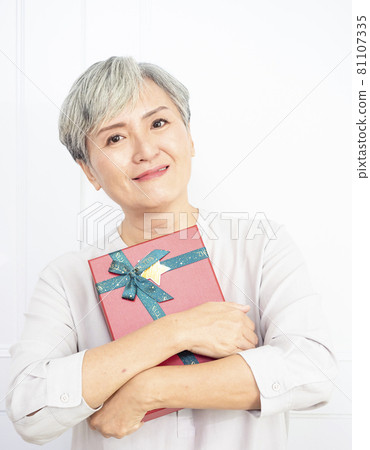Asian woman happy smile and holding gift box in hand. 81107335