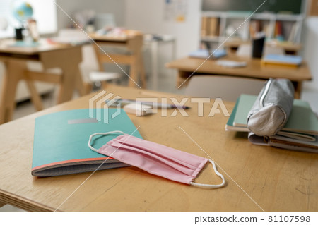 Protective mask on copybook and textile pencilbox on desk Protective mask on copybook and textile pencilbox on desk 81107598