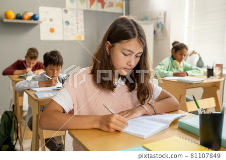 Caucasian elementary schoolgirl making notes at lesson Caucasian elementary schoolgirl making notes at lesson 81107849