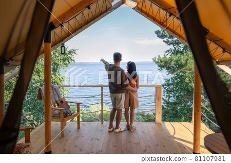 Backs of young man and woman standing in front of seaside Backs of young man and woman standing in front of seaside 81107981