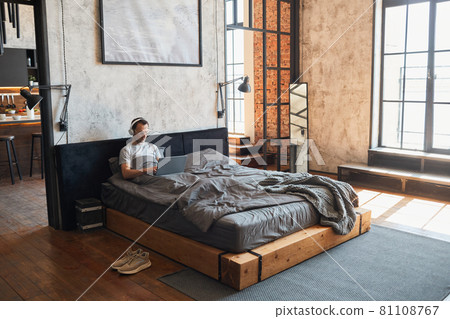 Man Relaxing in Bed Wide Angle 81108767