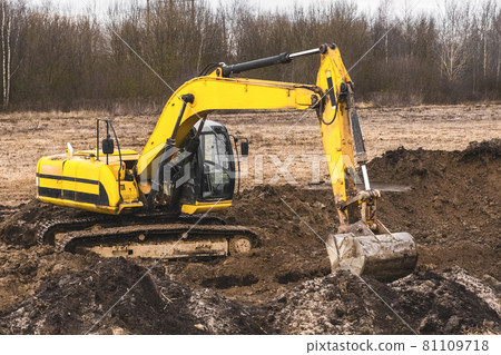 Construction worker on an crawler excavator equipment digs a trench in an industrial area. Excavation work with land and soil Construction worker on an crawler excavator equipment digs a trench in an industrial area. Excavation work with land and soil 81109718