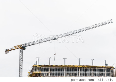 Industrial tower crane builds new concrete city building or apartments on construction site 81109719