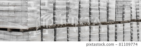 Large pile of packaged paving stone slabs industrial material on pallets at construction site Large pile of packaged paving stone slabs industrial material on pallets at construction site 81109774