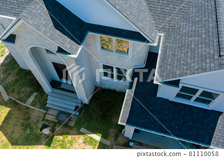 Aerial view of asphalt shingles roofing construction, the house with new window 81110058