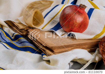 On the table in the synagogue are the symbols of Rosh Hashanah apple and pomegranate, shofar talith 81110070