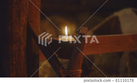 Candle illuminating stable on Christmas day Candle illuminating stable on Christmas day 81110178