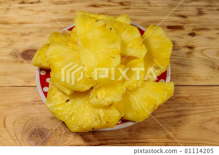 Pieces of pineapple in a plate on wooden table Pieces of pineapple in a plate on wooden table 81114205
