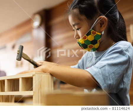 Elementary school girls enjoying woodworking 81114624