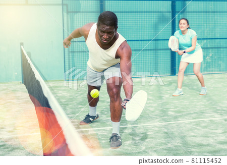 Sporty emotional man playing doubles paddle tennis 81115452