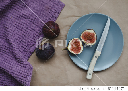 still life with ripe fresh figs with a knife and purple textiles on a table top view still life with ripe fresh figs with a knife and purple textiles on a table top view 81115471