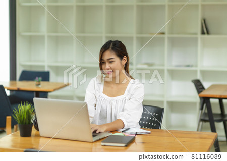 Elegant female college student sitting and using laptop computer in library Elegant female college student sitting and using laptop computer in library 81116089