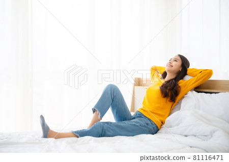 Happy woman relaxing on bed in bedroom. Freedom concept 81116471