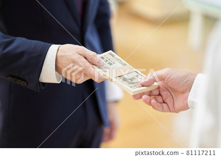 A man in a suit handing over money 81117211