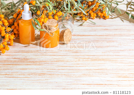 Hippophae homemade sea buckthorn oil in glass bottles with a pipette on the background with copy space, alternative herbal medicine and cosmetology 81118123