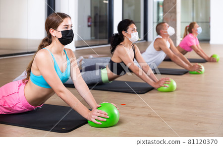 People in face masks lying in cobra pose 81120370