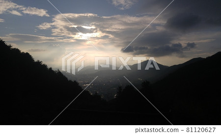 Foggy cityscape surrounded by mountains 81120627