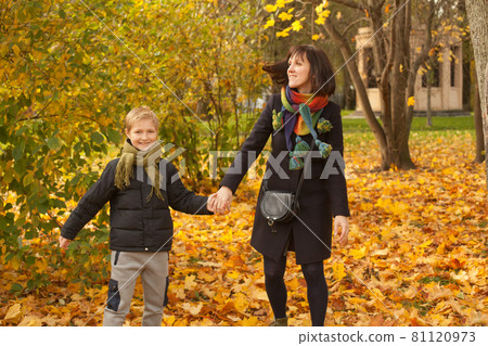Happy family mother and son smiling in fall leaves in autumn park Happy family mother and son smiling in fall leaves in autumn park 81120973