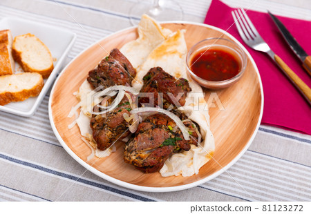 Grilled pork shashlik on lavash with onions and satsebeli Grilled pork shashlik on lavash with onions and satsebeli 81123272